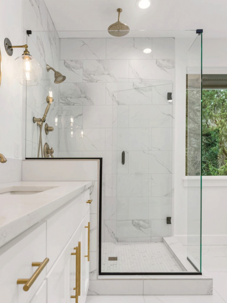 Beautiful custom glass shower with gold fittings.